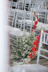 white chair with red and white flowers decoration in wedding ceremony