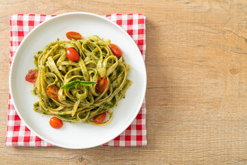 fettuccine spaghetti pasta with pesto sauce and tomatoes