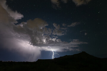 A summer monsoon storm delivers one of it's last lightning bolts as it passes into the distance...