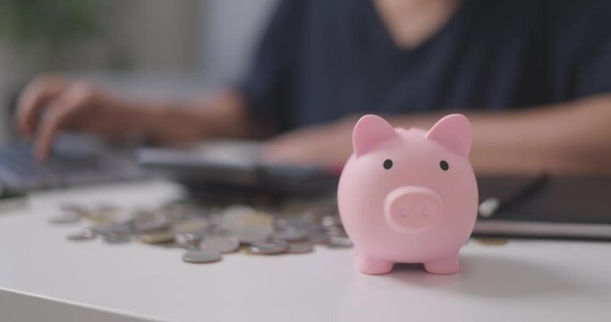 Woman sit at workplace desk working, close up. Saving money for the future. Female with a piggy bank in order to increase profits. Mortgage saving and finance concept
