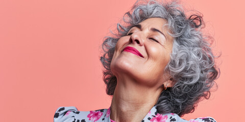 Close up of a confident middle aged woman with a peach copyspace background