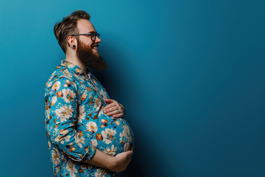 Happy pregnant transexual man with beard expectant trans father on blue background. Celebrating diversity in parenthood pregnant man gender norms expanding the definition of family concept. Copy paste