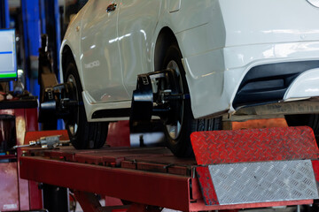 Car wheel alignment service in a car repair shop. Automation sensor equipment maintenance business