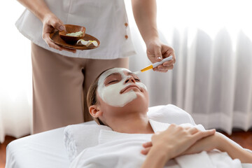 Obraz na płótnie Canvas Serene ambiance of spa salon, woman customer indulges in rejuvenating with luxurious face cream massage with modern daylight. Facial skin treatment and beauty care concept. Quiescent