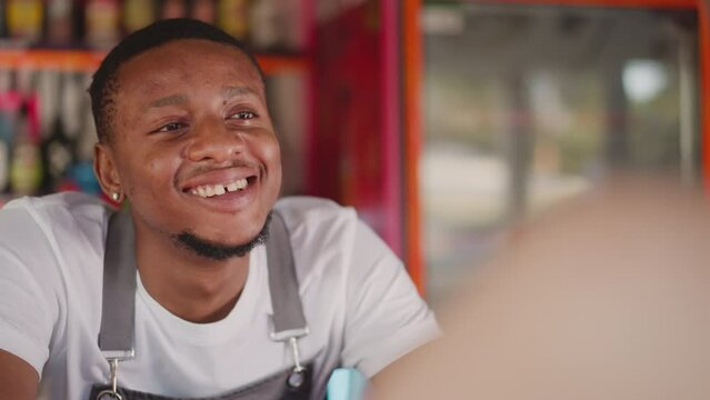 Barman enjoys communication with woman visitor in beach bar closeup. African American barkeep flirts with lady offering drinks. Personalized guest experience