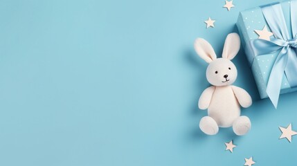 Wholesome Baby Accessories Concept: Top View Photo of Teether, Bunny, and More on Pastel Blue Background - Joyful Parenting and Childhood Moments.