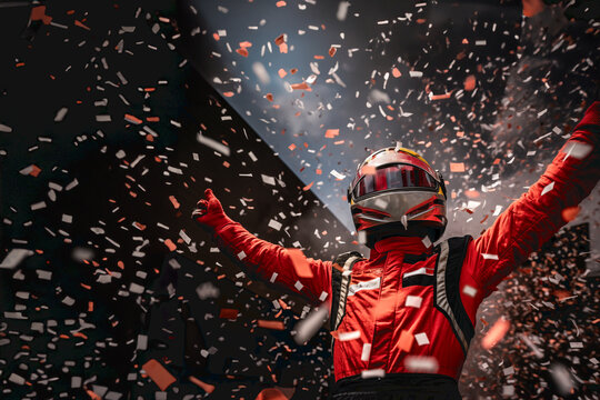 The winning driver of the Formula 1 car race raising his arms from the podium. Confetti flying.