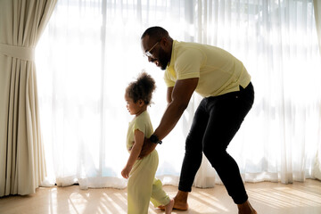 Enjoy happy love. black family African American father playing at home Little African girl smiling in white living room at home Happy Black African American Father's Day