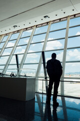 Voyageur à l'aéroport de Palma. Passager attendant son avion au terminal d'un aéroport. Silhouette d'un homme regardant le tarmac avant l'embarquement. Voyager en avion. Regarder le traffic aérien. - obrazy, fototapety, plakaty