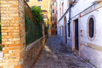 Fototapeta na wymiar Old town of Italian City of Venice with alley with colorful weathered facades on a summer day. Photo taken August 6th, 2023, Venice, Italy.