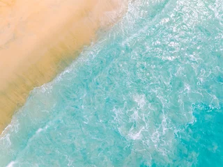  Top view beach with waves crashing on sandy shore,Beautiful waves sea surface in summer seascape background,Amazing beach colorful water background © panya99