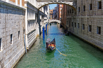 Fototapeta na wymiar Gondola at famous Dodge's Palace with Sighs Bridge and canal at City of Venice on a sunny summer day. Photo taken August 7th, 2023, Venice, Italy.