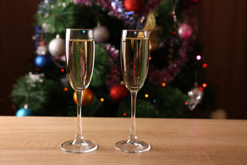 Two glasses of champagne on the table near the Christmas tree.