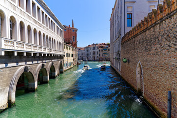 Old town of City of Venice with canal and motorboats and beautiful reflections in water on a sunny summer day. Photo taken August 7th, 2023, Venice, Italy.