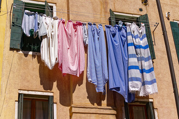 Close-up of drying clothes hanging on clothesline at the old town of Italian City of Venice on a sunny summer day. Photo taken August 7th, 2023, Venice, Italy.