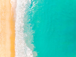 Top view beach with waves crashing on sandy shore,Beautiful waves sea surface in summer seascape background,Amazing beach colorful water background