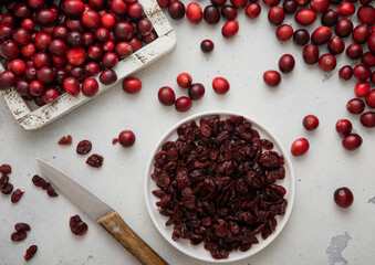 Plate with dried red sweet cranberry with ripe cranberries in wooden box.Top view.