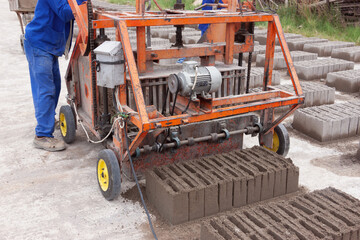 african man brick manufacturing machine , made from cement concrete and sand