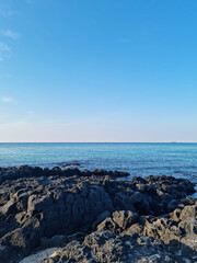 Fototapeta na wymiar This is a Jeju seascape with basalt rocks.