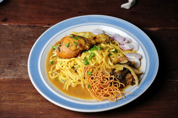 Northern food chicken khao soi in a bowl on a wooden table