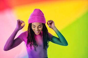 Woman posing on colored backgrounds in studio wearing trendy clothes