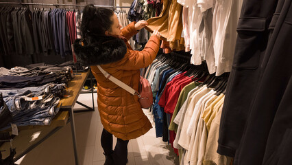 Woman looking for new clothes  in the store.