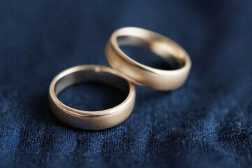 Obraz na płótnie Canvas Two simple wedding rings resting on a precious dark blue fabric