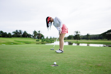 Obraz premium Professional woman golfer teeing golf in golf tournament competition at golf course, selective focus on golf ball,