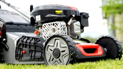 Fototapeta premium lawn mower on a green lawn on a sunny day