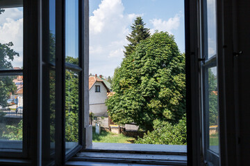 View of the courtyard from the open windows of the house on a summer day