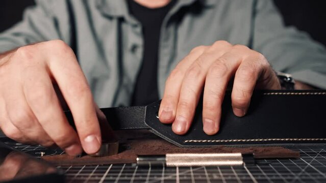 Tanner Makes A Hole In leather with a hammer Checks The Quality With His Fingers