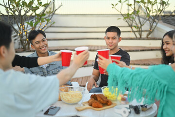 Group of friends celebrating happy hour and toasting drinks rooftop party