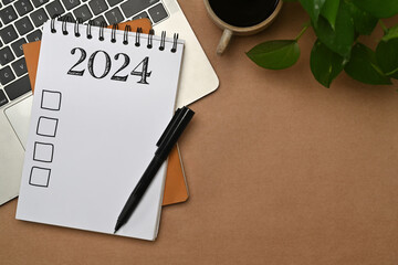 2024 resolutions list in a spiral notebook. Resolutions, plan, goals, checklist, idea concept