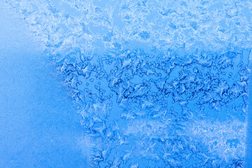 Fototapeta na wymiar Frozen window in winter day (blue background)