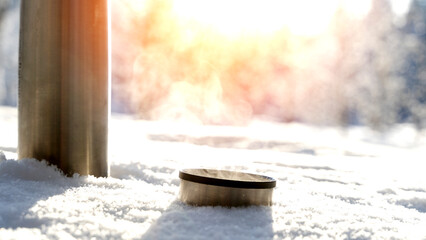 Thermos with a hot drink or tea in the snow