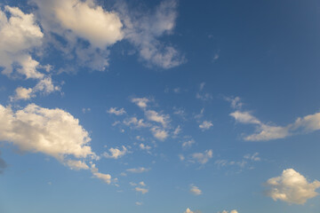 Beautiful blue sky with white clouds lit by the sun.