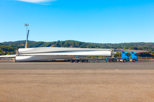 Wind turbine blades are loaded onto a cargo truck in the seaport of Ferrol in Spain.