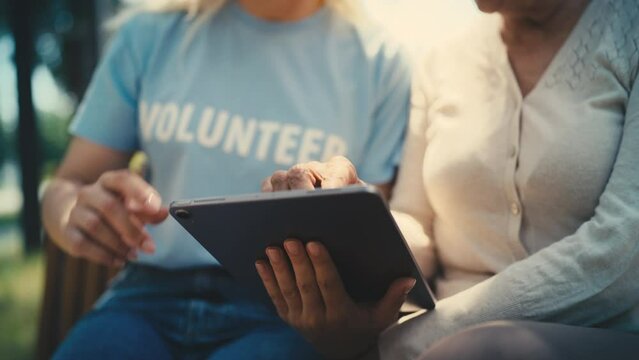 Volunteer and senior woman filling out online form on tablet, social programs