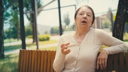 Woman in her 60s sitting on bench and feeling a hot flash, female health problem