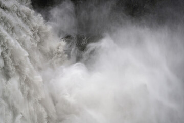 Die Kraft des Wassers am Wasserfall der in die Tiefe stürzt - obrazy, fototapety, plakaty