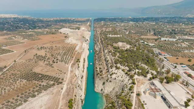 Corinth Canal, Greece. The Corinth Canal is a sluiceless shipping canal in Greece, connecting the Saronic Gulf of the Aegean and the Gulf of Corinth of the Ionian Sea, Aerial View, Departure of the c