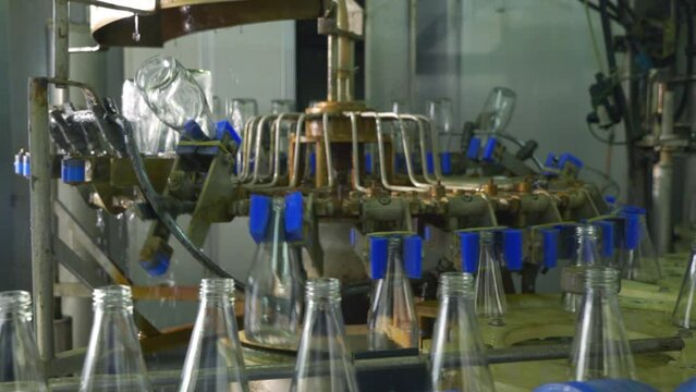 In a modern distillery a conveyor displays empty glass bottles for alcoholic beverage production. Clean automated technology promises efficient bottling and manufacturing.