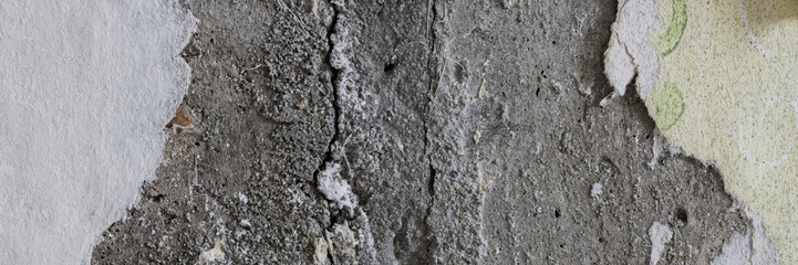 Torn old faded paper wallpaper on a concrete wall. Ragged scraps of white paper on a gray background. Vintage texture for background and design. Closeup view with copy space for text.