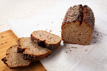 Sliced dark rye hemp seed bread on linen towel. Healthy pastry