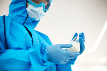 Female lab scientist examining samples in a test tube, working in an african american woman