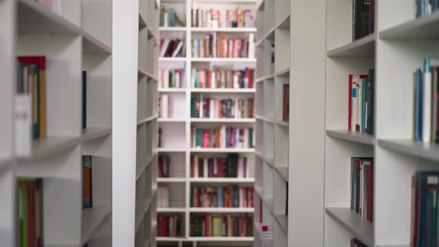 Empty aisle between high bookshelves