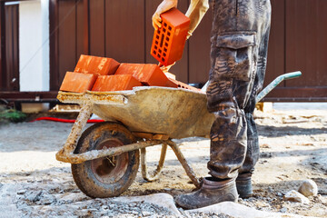 Builders are moving orange bricks.