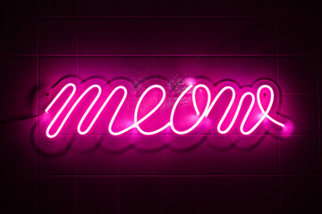 Neon meow sign glows in pink against dark night background. Decorative neon light for home, bar or...