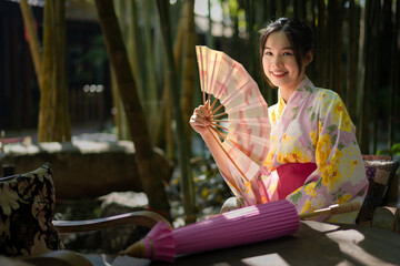 Pretty the Traveller Young Asian woman wearing a Japanese traditional kimono dress, a Yukata dress,...