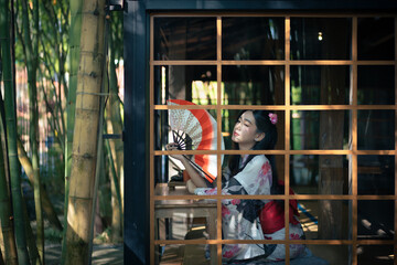 Pretty the Traveller Young Asian woman wearing a Japanese traditional kimono dress, a Yukata dress,...
